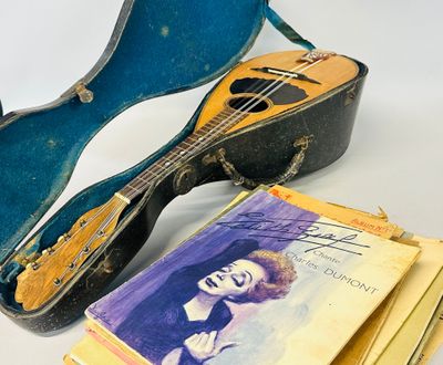 a guitar, a book, and a guitar case on a table