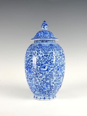 un vase bleu et blanc avec un couvercle posé sur une table