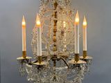 a crystal chandelier with five lit candles on it