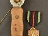 two medals and a sword on a table with a black background