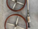 two wooden steering wheels on the floor next to a pair of shoes