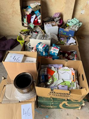 une boîte remplie d'objets posée par terre à côté d'une pile de boîtes