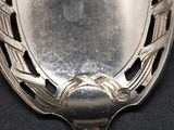 a silver spoon with a decorative design on it
