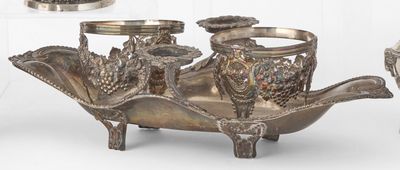 trois vases en argent et un plateau en argent posés sur une table