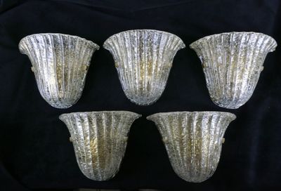 quatre vases en verre argenté posés sur un tissu noir