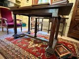 a large wooden table on a red rug in a room