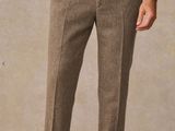 une photo d'un homme en chemise blanche et pantalon marron