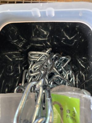 un récipient contenant tout un tas de crochets métalliques