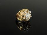 an image of a gold and diamond ring on a black surface