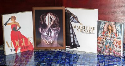 quatre livres posés sur une table sur laquelle se trouve la photo d'une femme