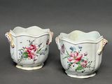 two vases with flowers painted on them on a gray surface