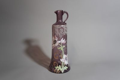 un vase violet orné de fleurs, posé sur une table