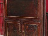 une armoire en bois surmontée d'un miroir, dans une pièce