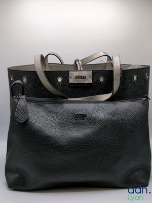 two black and grey handbags sitting next to each other on a table