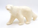 une petite figurine d'ours polaire blanc sur fond blanc