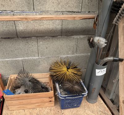 beaucoup de pinceaux dans une boîte en bois posée par terre