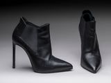 two pairs of black leather ankle boots on a grey background