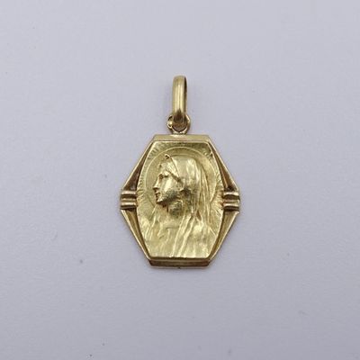 Gros plan sur un pendentif en or orné d'un visage de femme