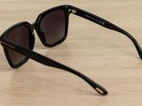 a pair of black sunglasses sitting on top of a wooden table