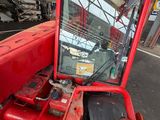 a red tractor that is parked in a garage