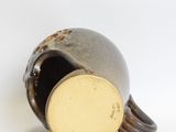 a close up of a brown vase with a yellow lid