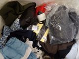 a pile of clothes in a plastic bag on a bed