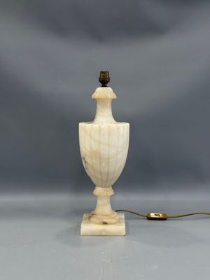 une image représentant une lampe blanche avec un cordon marron sur fond gris