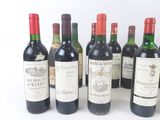 several bottles of wine are lined up on a white surface