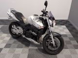 une moto argentée et noire garée sur un sol à damier