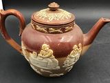 a brown tea pot with a brown lid on a black table
