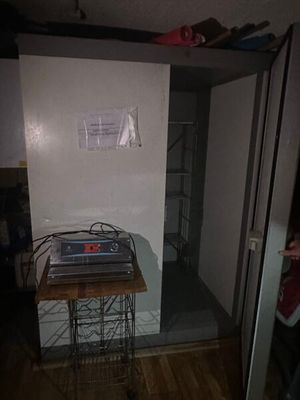 une petite table sur laquelle est posé un ordinateur portable, dans un coin de la pièce