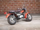 a red motorcycle parked in front of a brick wall