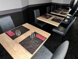 tables and chairs in a restaurant with place mats and place settings