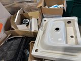 a white sink sitting in a pile of boxes