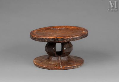 an old wooden table with a circular base and a wooden top