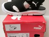 puma black and white sandals on top of a red box
