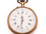 a gold pocket watch with roman numerals on the face