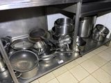many pots and pans sitting on a shelf in the kitchen