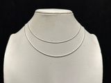a close up of a white mannequin with a necklace on it