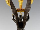 an image of a statue of an angel holding two candles