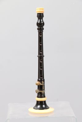 an image of a black and gold flute on a clear stand