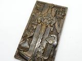 une photo d'une plaque métallique sur laquelle figurent un homme et un chien