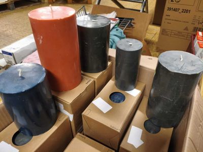 Des cartons de bougies sont empilés les uns sur les autres par terre