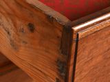 close up of a wooden desk with a red cloth drawer underneath it