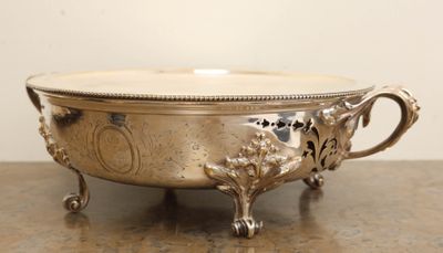a silver bowl on a table with a handle on it