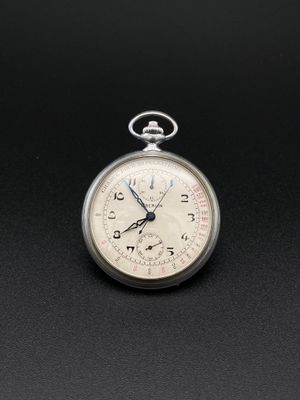 une montre de poche en argent posée sur une surface noire