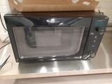 a microwave sitting on top of a counter with a box on top of it