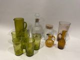 des bouteilles et des verres posés sur une surface blanche, avec une bouteille à l'arrière-plan