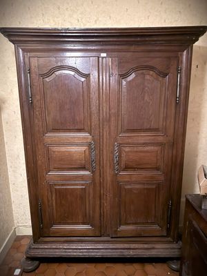 une grande armoire en bois dans le coin d'une pièce