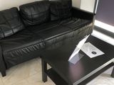 un canapé en cuir noir et une table basse dans un salon